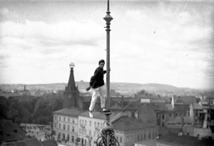 Fotografia z zasobu Narodowego Archiwum Cyfrowego; Feliks Nazarewicz; Człowiek - mucha Feliks Nazarewicz wykonujący akrobacje na dużej wysokości; sierpień 1928; Sygn. 1-K-12528